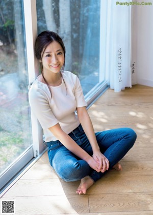 A woman in a pink skirt is smiling at the camera.