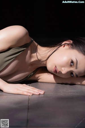 A woman in a green dress laying on the ground.