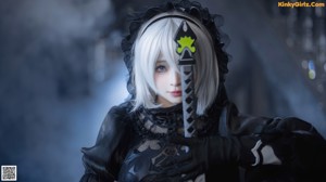 A woman in a black dress holding a sword.