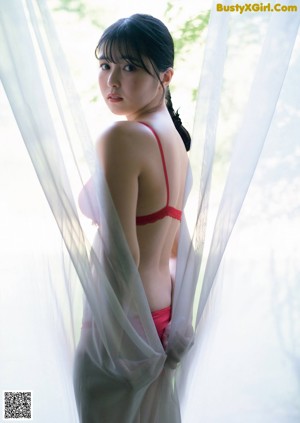 A woman in a red and white dress posing for a picture.