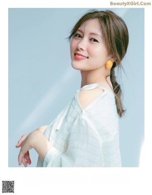 A woman in a white blouse posing for a magazine.
