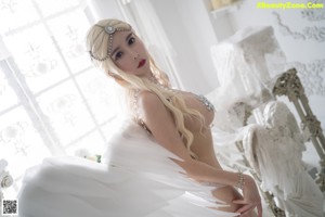 A woman in a white lingerie posing for a picture.