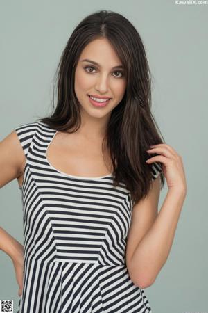 A woman in a gray dress posing for a picture.