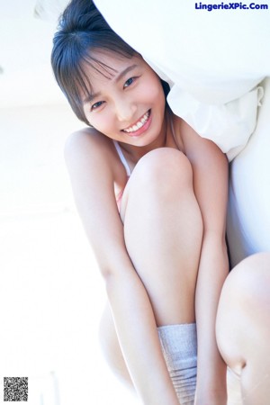 A young woman in a pink bra and panties posing for the camera.