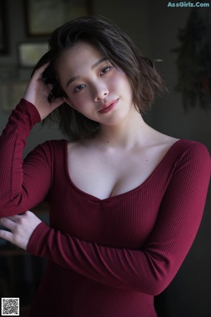 A woman in a red sweater is posing for a picture.