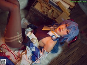 A woman with blue hair sitting on a white fur rug.