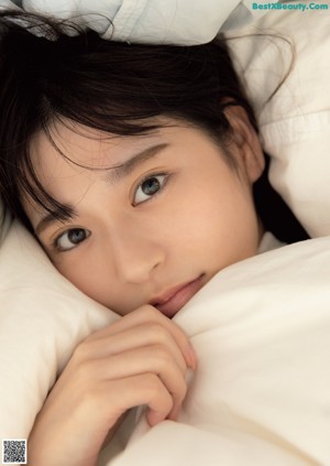 A woman laying on a bed in a white underwear.