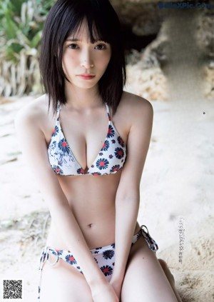 A woman in a red bikini standing in front of a green wall.