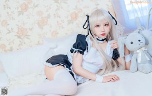 A woman sitting on a couch holding a teddy bear.