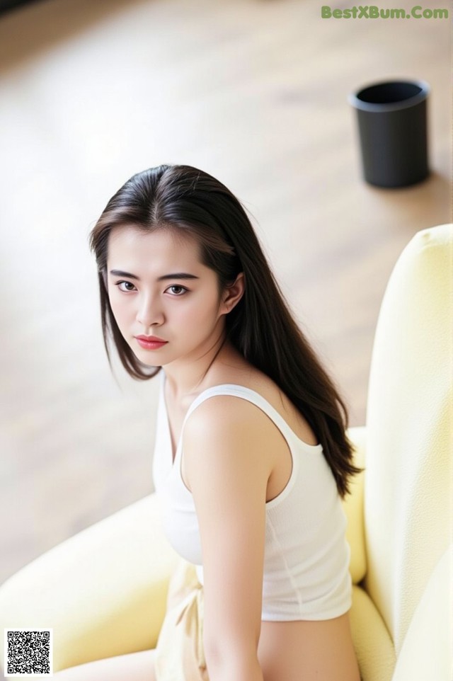 A woman sitting on top of a yellow chair.