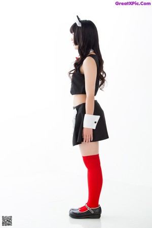 A woman in a black and white dress and red stockings.