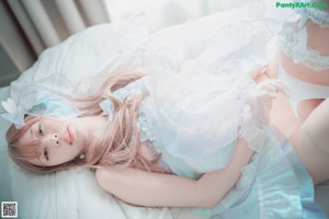 A woman in a white lingerie laying on a bed.