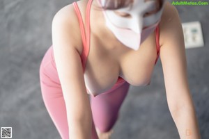 A woman wearing a pink underwear and a face mask.