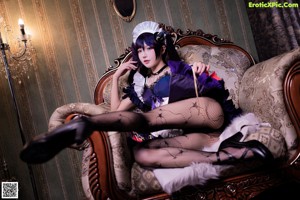 A woman dressed in a maid outfit posing for a picture.