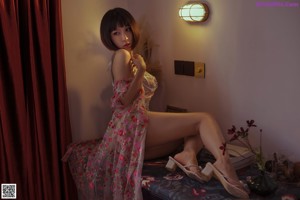 A woman in a floral dress posing for the camera.