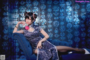 A woman sitting on a blue couch in a room.