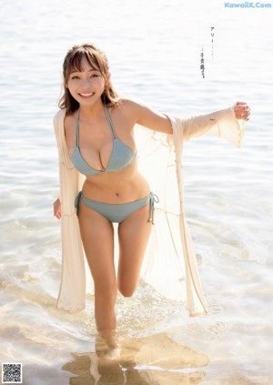 A woman in a blue bikini posing for a magazine.